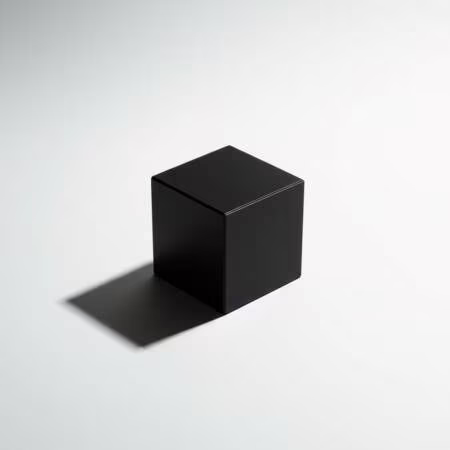 Чёрный куб на белой поверхности с резкой тенью